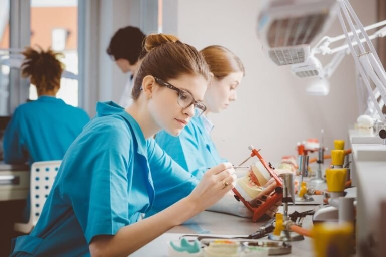 estudiantes practicando en laboratorio de mecanica dental